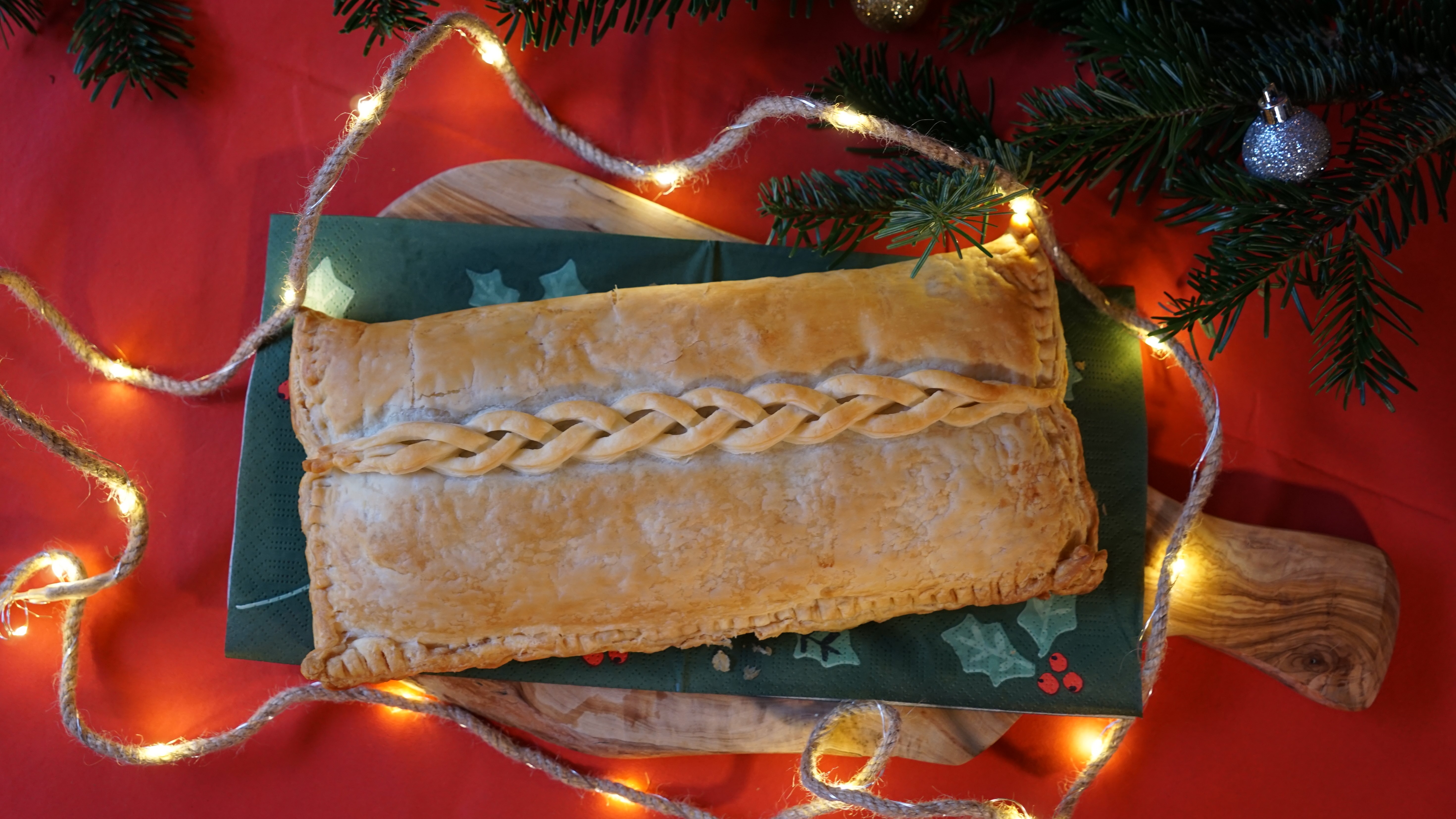 Bladerdeegrol met kastanjechampginons en knolselderij op een houten plank op een kersttafel